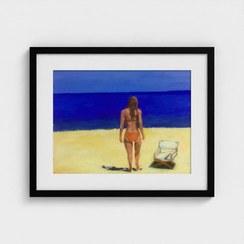 Black-framed Formentera beach print by Colin Galloway, with a woman facing blue sea beside a sun lounger.