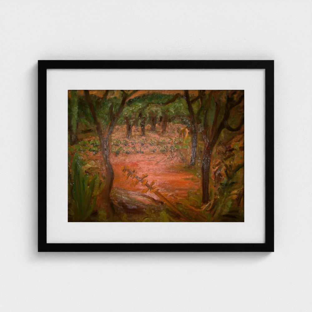 Black-framed print of Colin Galloway’s Santa Ines evening landscape, with dark trees and warm orange earth.