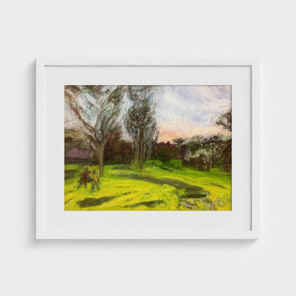 White-framed Surrey spring evening print by Colin Galloway, with tall trees, green grass and long shadows.
